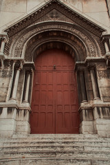 The amazing facade of the Basilica, large maroon vintage doors. Basilica Sacré Coeur, Paris, France.
