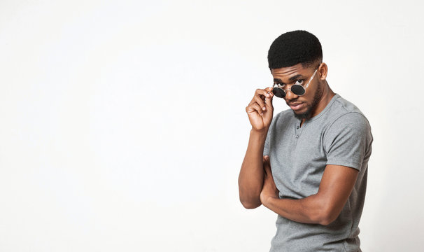 Handsome black man adjusting his sunglasses and looking at camera