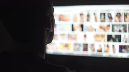 Young mand watching naked women in the computer screen