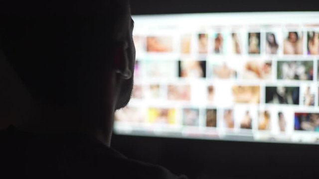 Young mand watching naked women in the computer screen