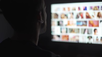 Young mand watching naked women in the computer screen