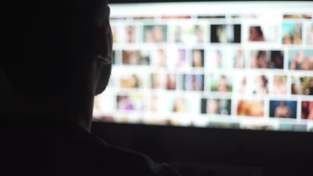 Young mand watching naked women in the computer screen