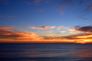 sunset over the sea,sky,clouds,view,calm,sunrise,nature,orange,blue,light,sunlight
