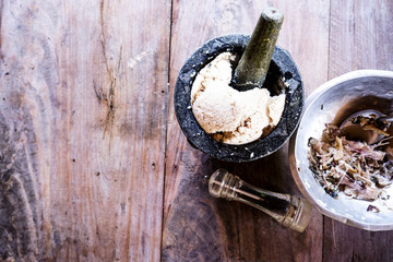 Fish is pounding in a mortar. dark brown wood background