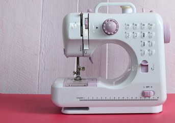 Electric sewing machine on pink background