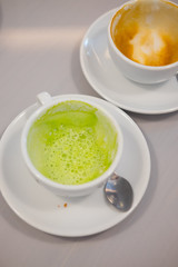 Close up dirty coffee and green tea cup