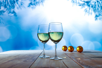 Two glasses with white wine on an old wooden table in a Christmas mood  