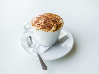 White Cup of cappuccino on a white table.
