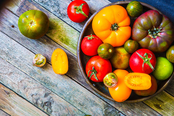 Fresh various tomatoes on rustic wooden table