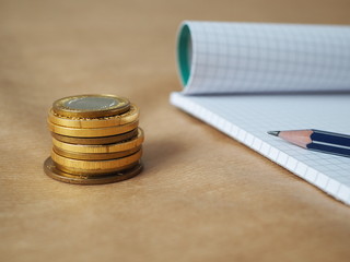 Gold coins and pen on a table, cash