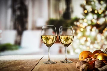 Keuken foto achterwand Two glasses with white wine on an old wooden table in a Christmas mood   © magdal3na