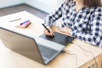 Fototapeta premium Close-up of female hands using digital graphic tablet at modern office