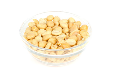 Roasted and salted peanuts in glass bowl. Shelled Arachis hypogaea, also called groundnut or goober, used as a snack. Isolated macro food photo, close up, from above, on white background.