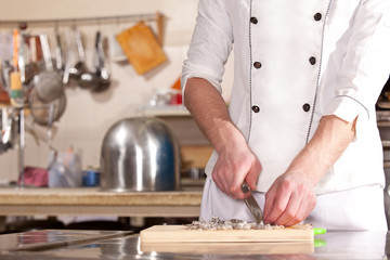 Cook cutting vegetables on the kitchen