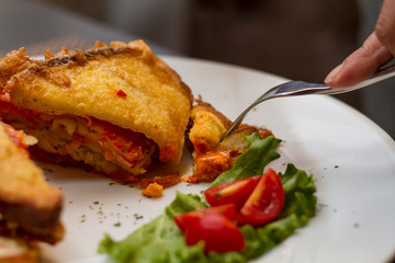 Man eating some hot fried sandwiches with a fork