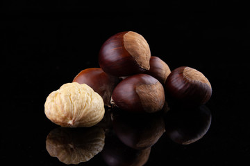 Chestnuts on wooden board and autumn leaves