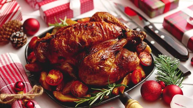 Roasted whole chicken or turkey served in iron pan with beautiful Christmas decoration. Placed on white rustical wooden background. Top view.