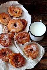 Tasty donuts on wooden table with cup of milk