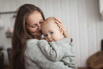 Mom and baby together in gray knitted sweaters