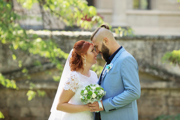 Just married loving hipster couple in wedding dress and suit in the park. Happy bride and groom walking running and dancing. Romantic Married young family.