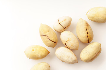 Fototapeta na wymiar Pecan nuts in nutshells isolated. Overhead image, white background