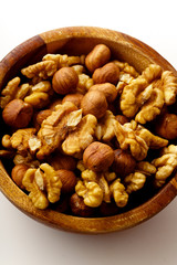 Overhead image of assorted nuts in wooden bowl on white background with copy space
