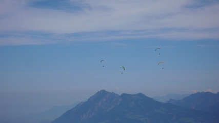 paragliders flying in the sky above the mountains of Switzerland