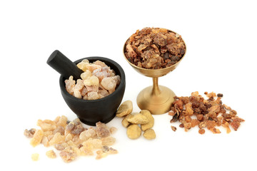 Gold Frankincense and myrrh in a mortar with pestle, old metal bowl and loose on white background.