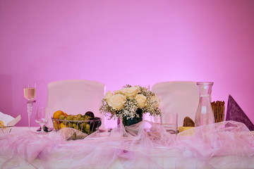 Main wedding table with decoration and bouquet on pink modern background