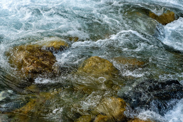 Obraz premium Powerful flow of water over the stones, mountain river close up.