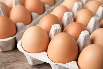 Raw chicken eggs in carton, closeup view