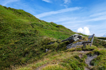 A wooden bench at the top of the Alps, a place for tourists to relax and look at beautiful landscapes.