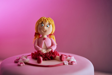 Obraz na płótnie Canvas Birthday pink cake for a girl with a cute girl decoration on top