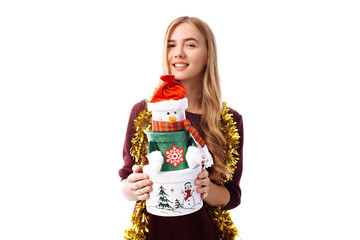 Happy young woman in Santa Claus hat, in hands, a gift box on a white background.