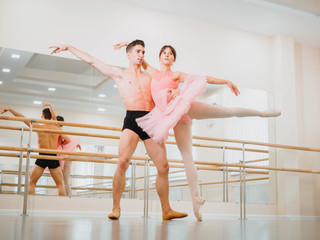 Rehearsal in the ballet hall or studio with minimalism interior. Young professional sensual dancer's couple in beautiful costumes dancing together © kohanova1991
