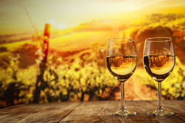 Two glasses with wine on a wooden table in an autumn setting   