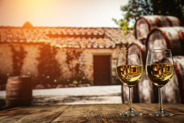 Two glasses with wine on a wooden table in an autumn setting   