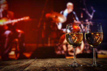 Two glasses with wine on a wooden table in an autumn setting   