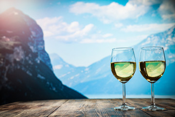 Two glasses with wine on a wooden table in an autumn setting   