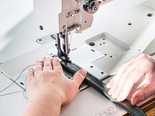 craftsman sews green belt on sewing machine