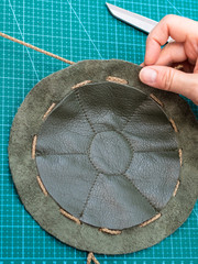 craftsman inserts a cord in the sewn pouch