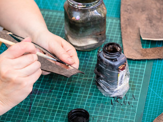craftsman stains the edges of carved leather item