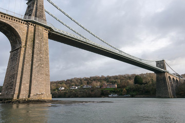 Obraz premium A view of the historic Menai suspension bridge spanning the Menai Straits, Gwynnedd, Wales, UK.