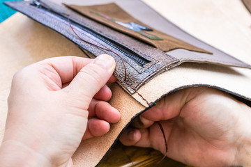 craftsman stitches the inner pocket in handbag