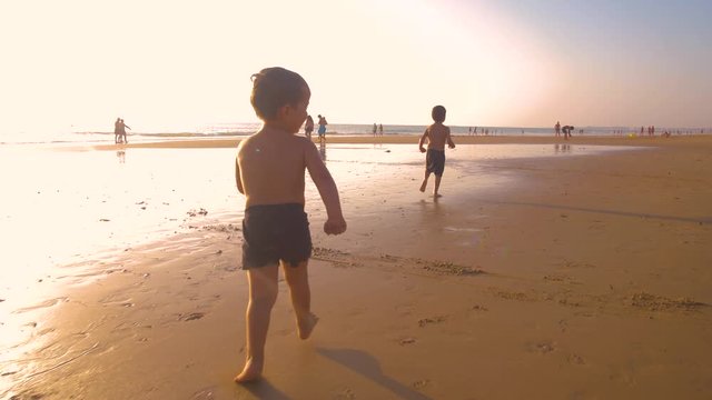 4K Slow motion - Two little brothers running, playing and enjoying while the camera chase them