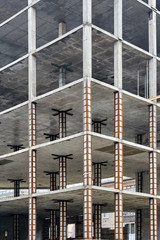 Monolithic construction of a multi-storey apartment building. Construction site. Unfinished construction and reinforced concrete house frame