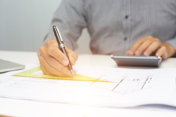 A businessman using calculator and holding money for calculate tax in office.concept