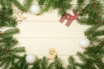Fototapeta na wymiar Christmas tree frame branches, balls and christmas toys on wooden background with copy space. Horizontal template for design
