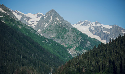 Fototapeta na wymiar Caucasus mountain range in summer, snow-capped peaks, Sunny day