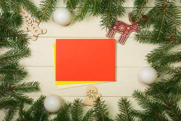 Fototapeta na wymiar Christmas tree frame branches, envelopes, balls and christmas toys on wooden background with copy space. Horizontal template for design